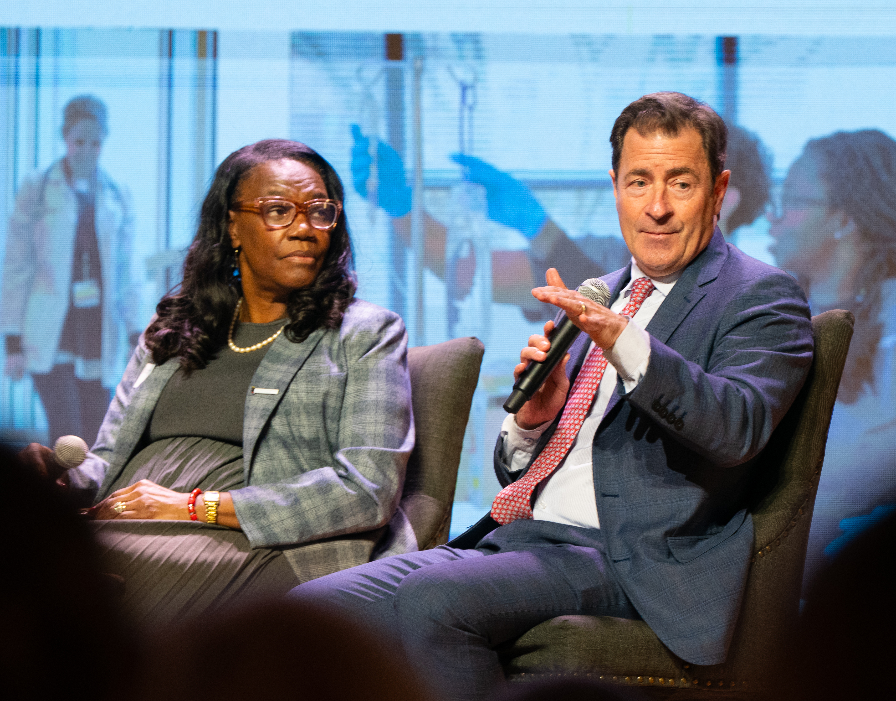 UM School of Nursing Dean Yolanda Ogbolu listens as UM School of Medicine Dean Mark Gladwin addresses the audience.